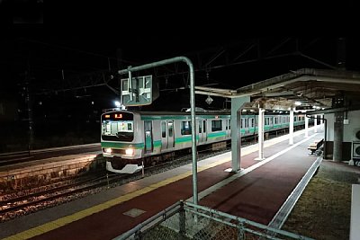 夜のホームにE233系が停車しています